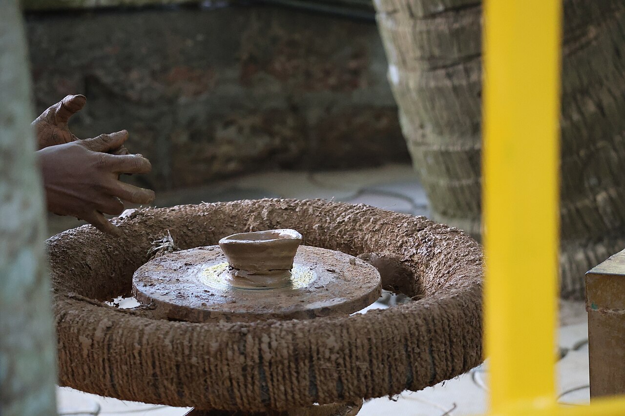 Hands shaping clay on the wheel